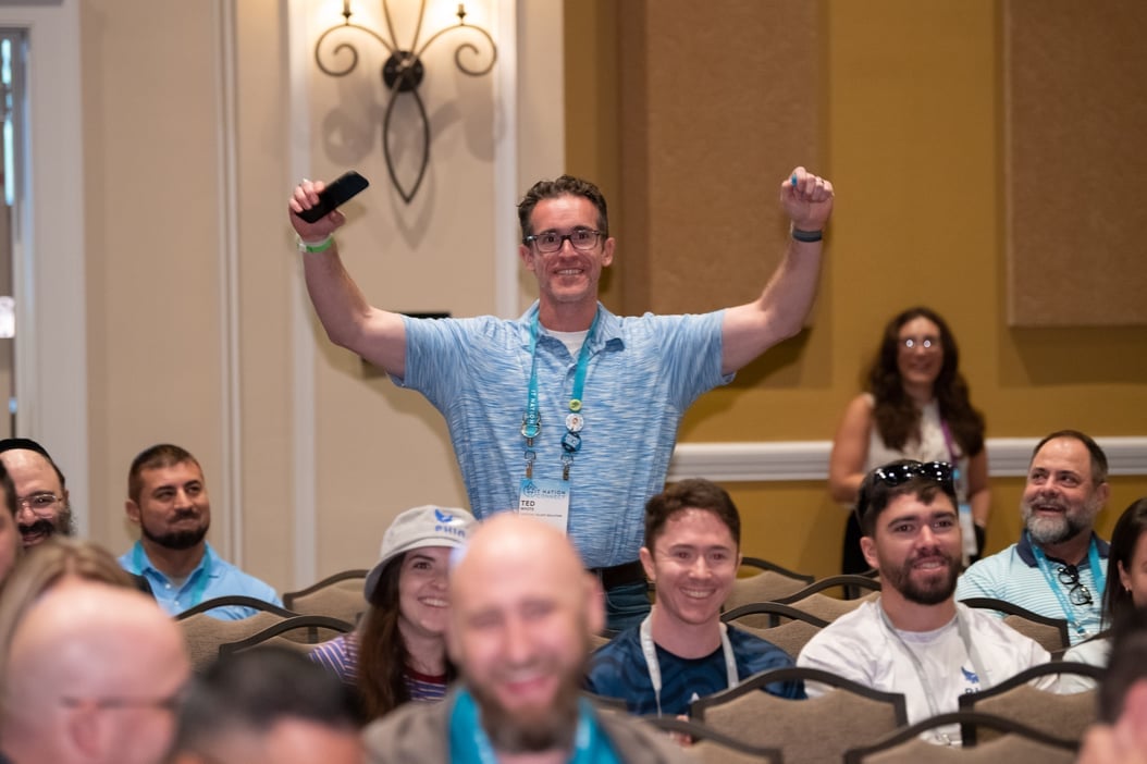 attendee with arms triumphantly raised in the air